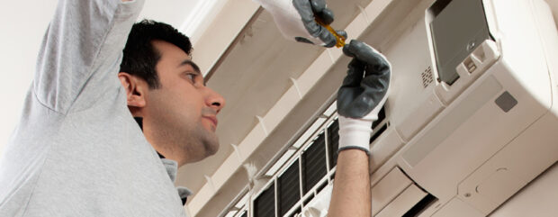 Engineer performing maintenance on an air conditioning unit.